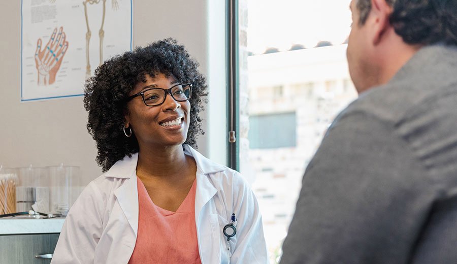 adult female health professional talking to a male in a clinic setting