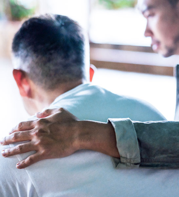 Son comforting his father with hand on the shoulder