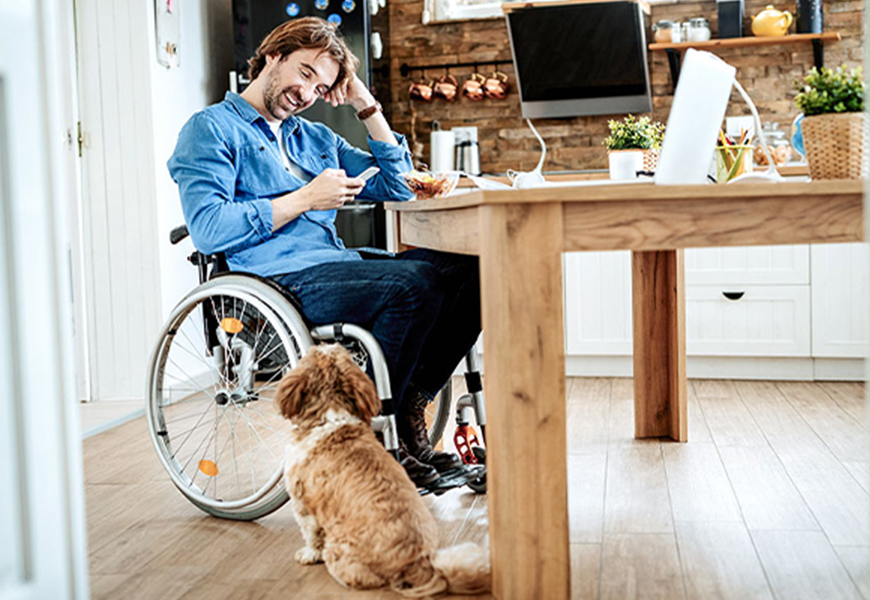 Man in wheelchair at home using his phone