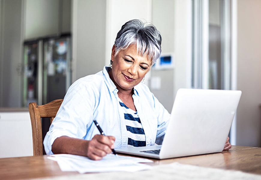 Older woman reviewing bills on her computer at home