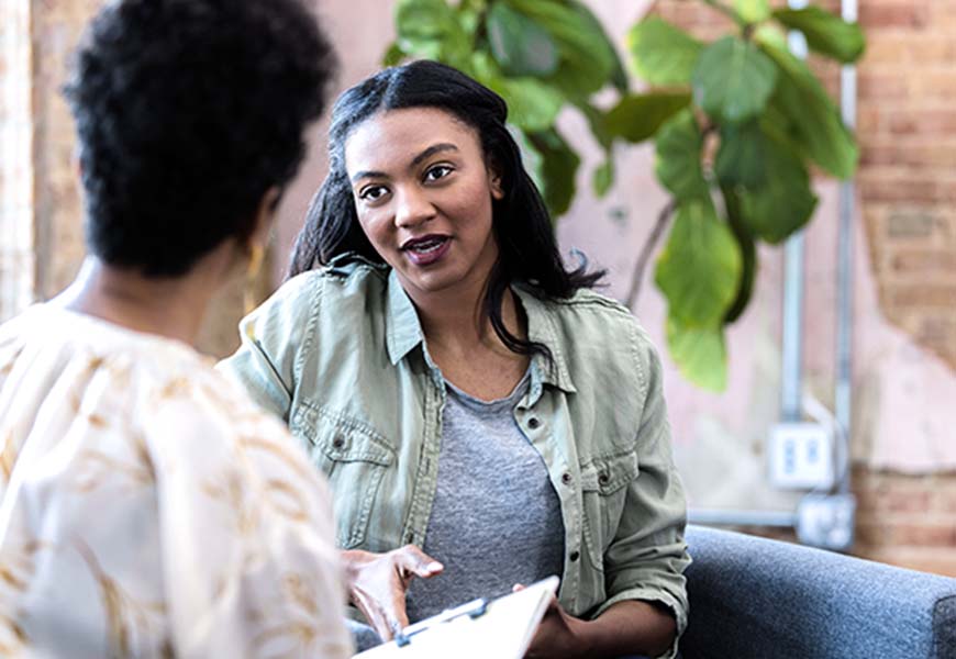 Young adult woman meets with her therapist at their office